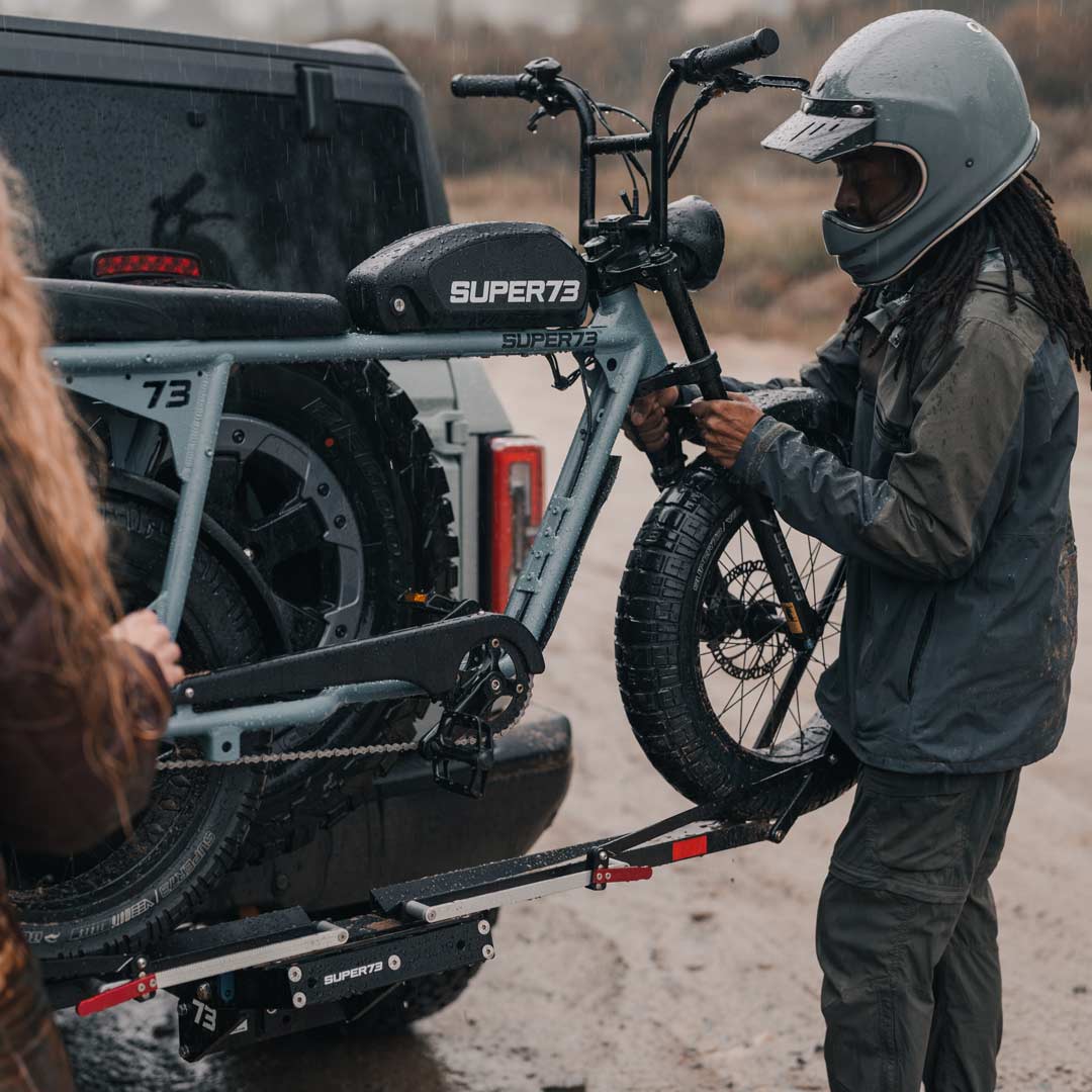 Lifestyle image showing a SUPER73-S2 ebike being taken off of 1UP USA x SUPER73 Bike Rack.