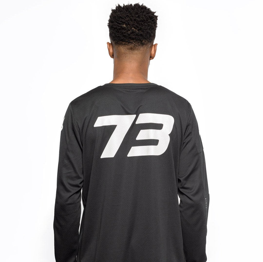 Male model back view of black Premium long sleeve athletic moto hoon jersey. @color_black
